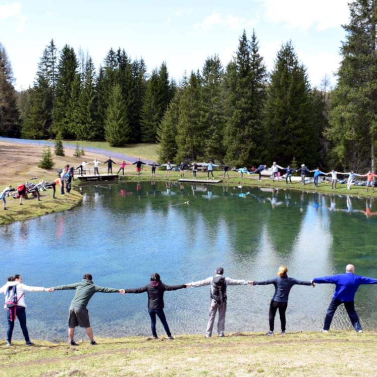 Giovani ignaziani in cerchio intorno a un laghetto per celebrare la cura del creato